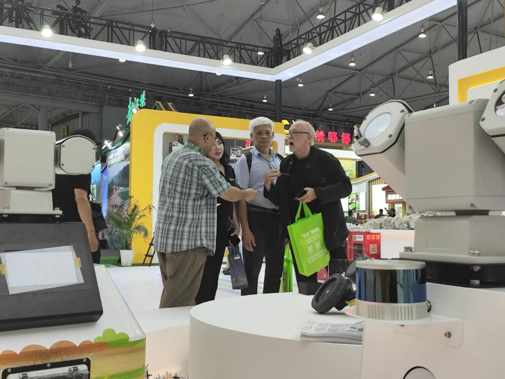 GC AGV&AMR Robotics representatives meeting international customers and discussing warehouse automation technologies at an industry exhibition.