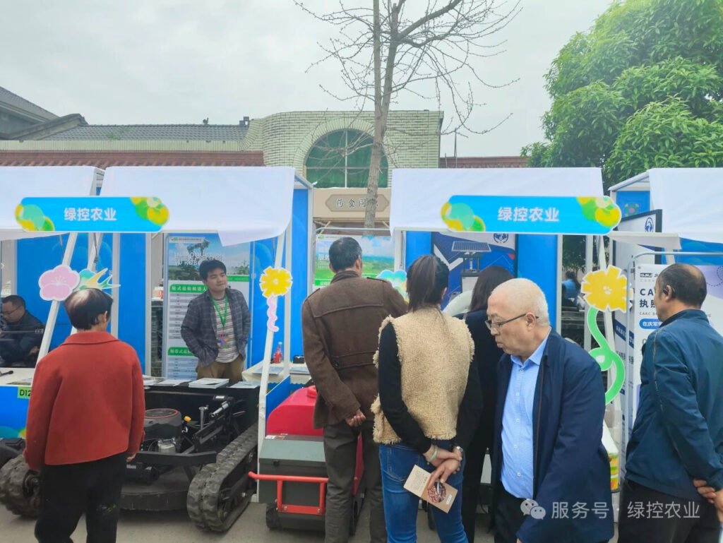 Group of visitors checking out agricultural robot hardware at the outdoor booth